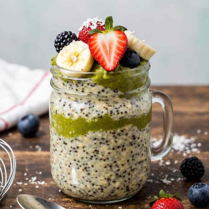 Final prepared Matcha Overnight Oats Recipe in a mason jar with fresh fruit toppings and coconut flakes.